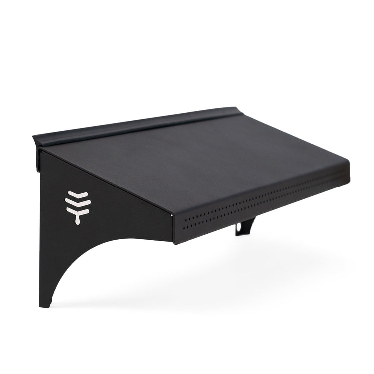 A black weather guard accessory for a hive, designed to protect the entrance from weather conditions.